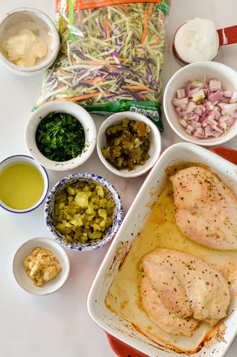 Ingredients for chicken salad including chicken breast, fresh dill, pickles, pickle juice, jalapenos, shallot, Greek yogurt, mayo, coleslaw mix and dijon