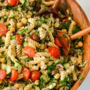 Pasta salad with garbanzo beans in a large serving bowl.