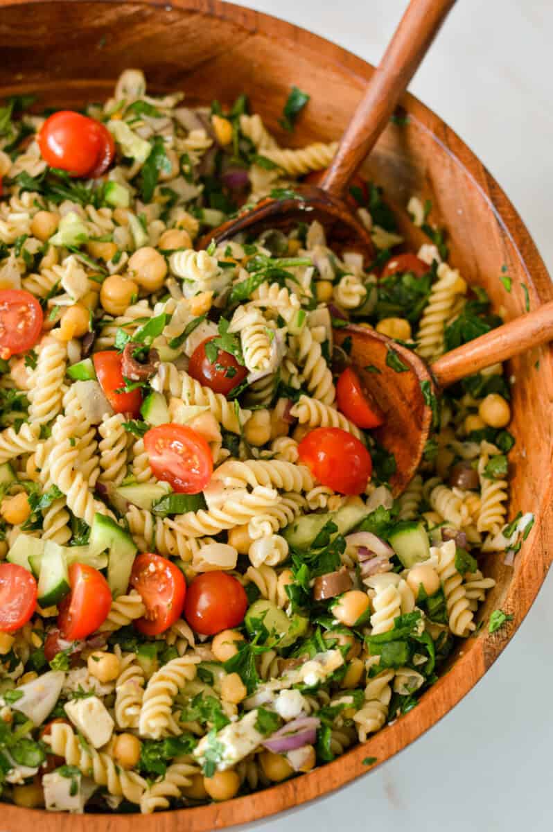 Pasta salad with garbanzo beans in a large serving bowl.