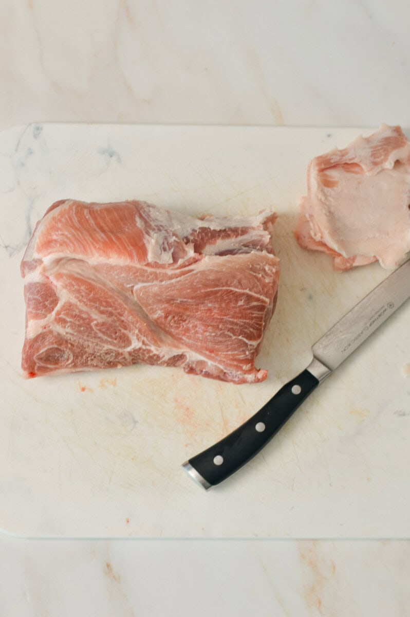 Pork shoulder being sliced.