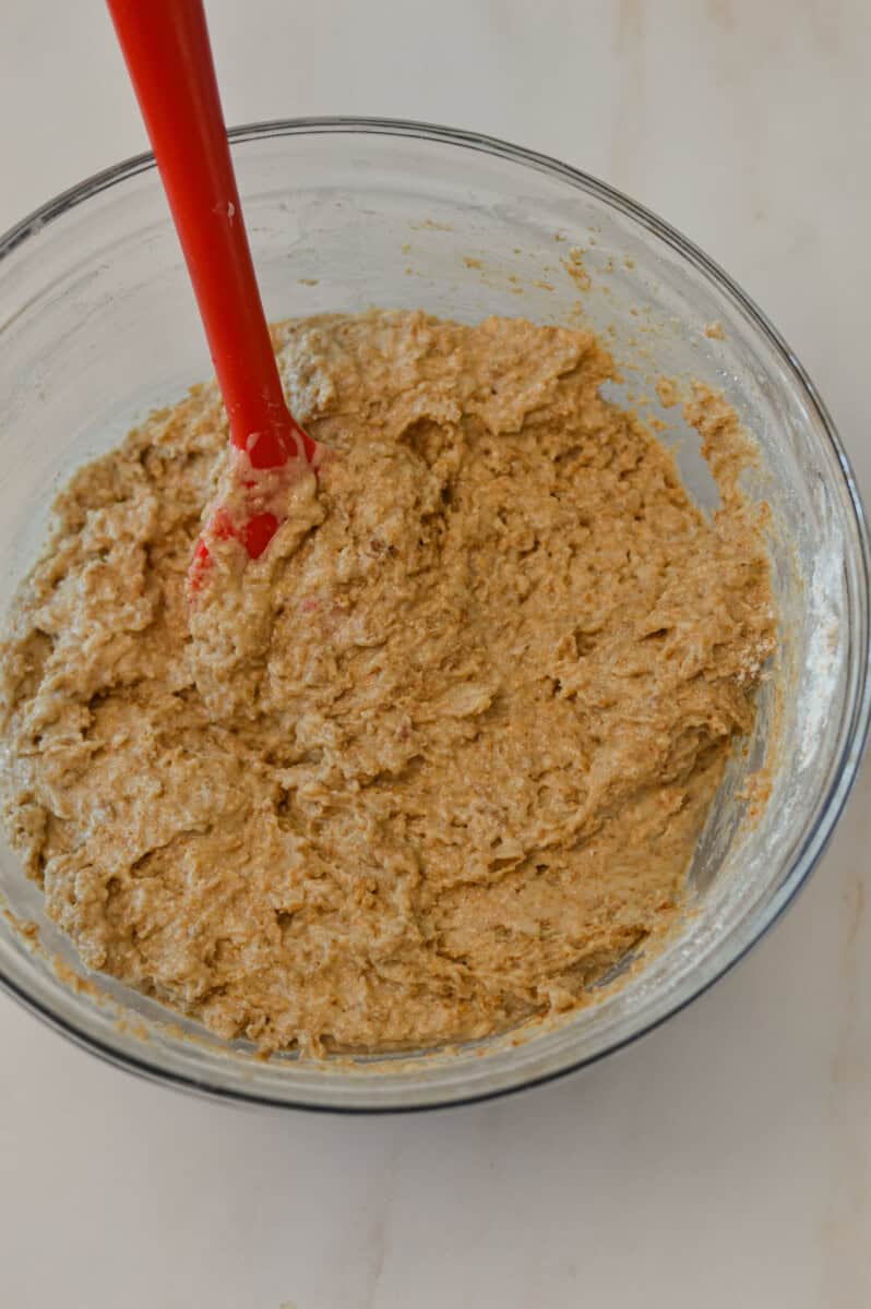 Wet and dry ingredients combined in a mixing bowl.