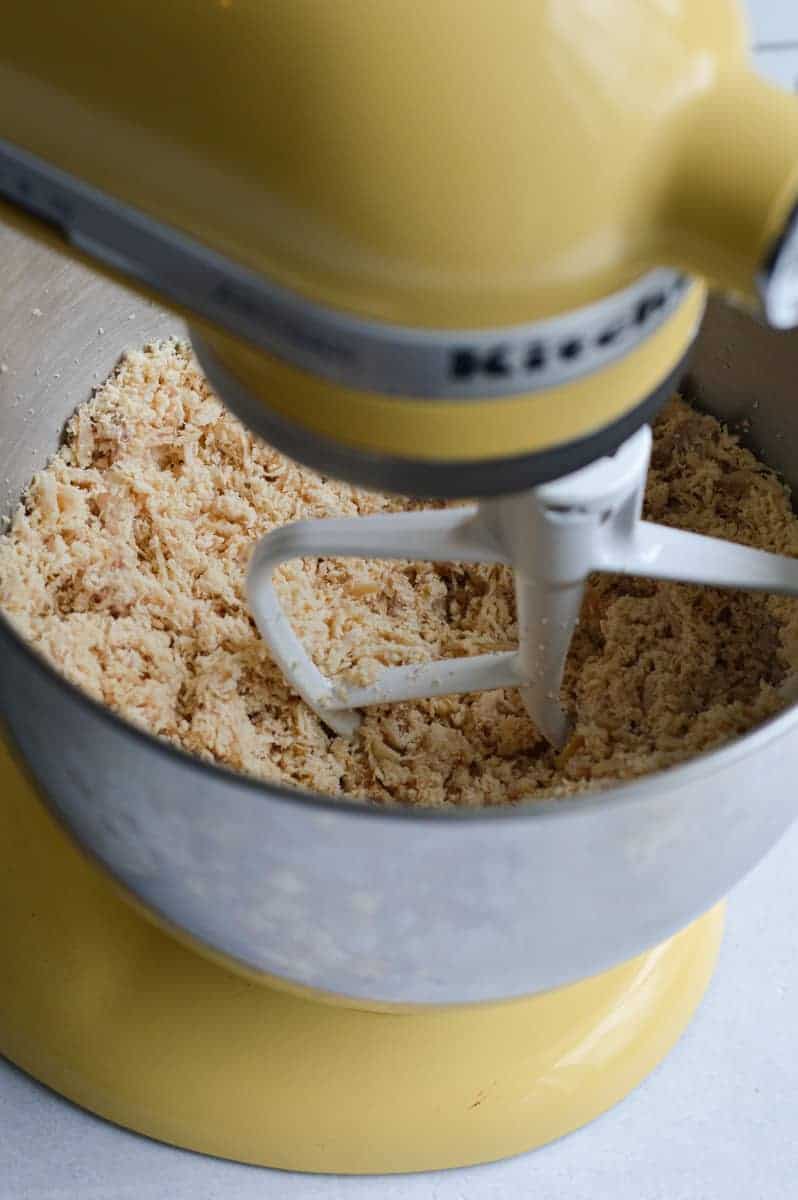Chicken being shredded in a stand mixer