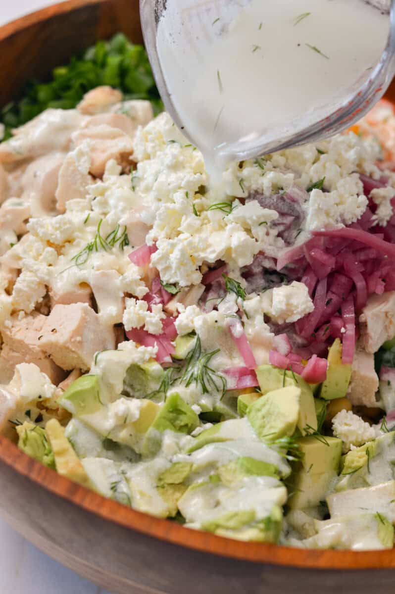 close up of pouring dressing over salad