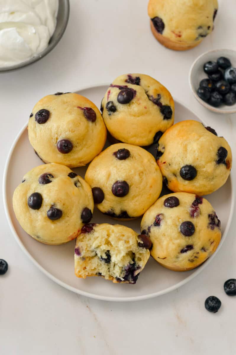 Yogurt muffins on a plate with a bite taken out of one.