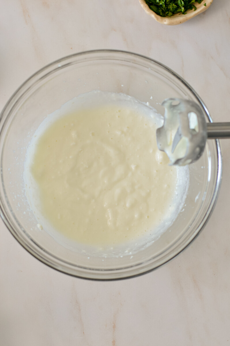 Cottage cheese blended in a bowl with an immersion blender.