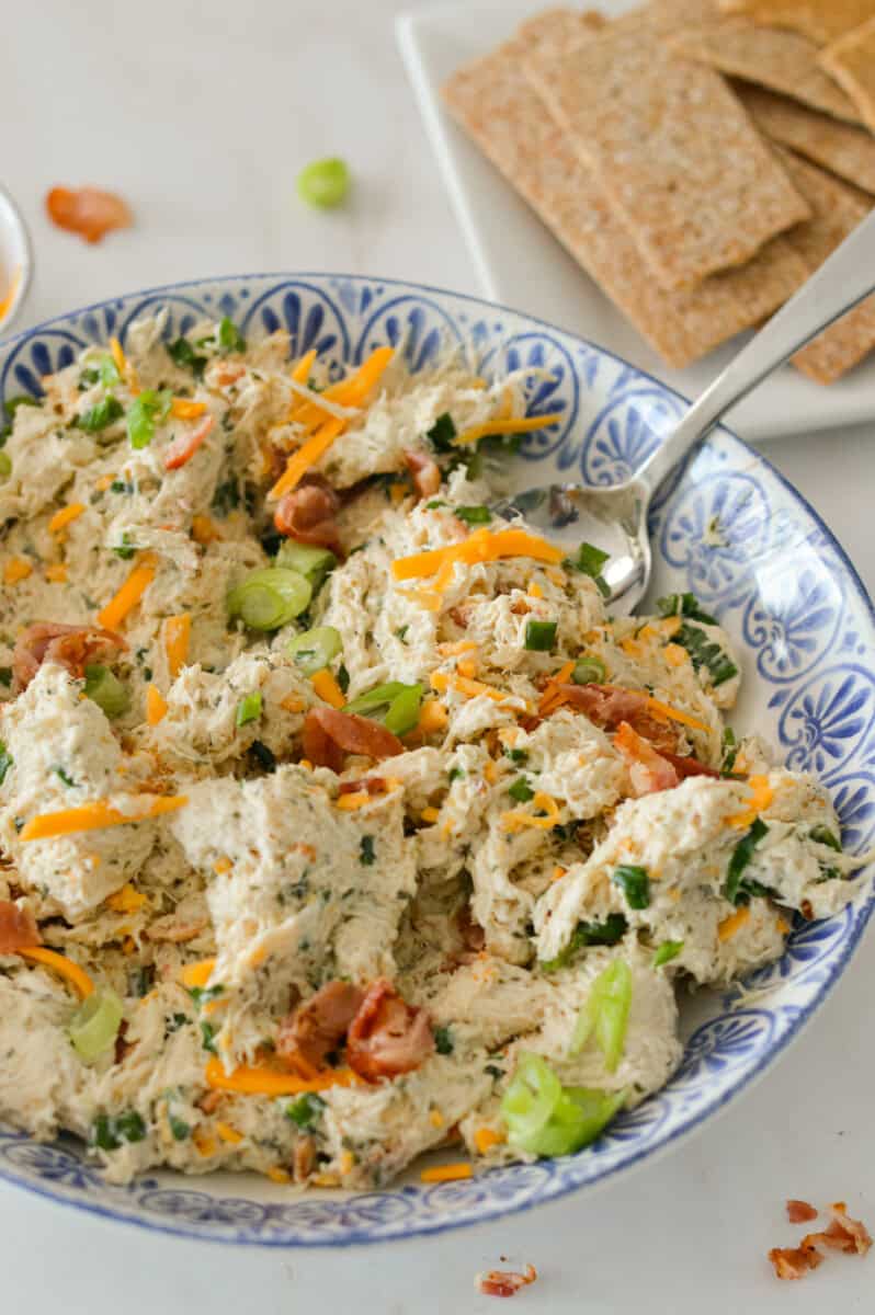 High-protein chicken bacon ranch chicken salad in a bowl with a spoon lifting it up.