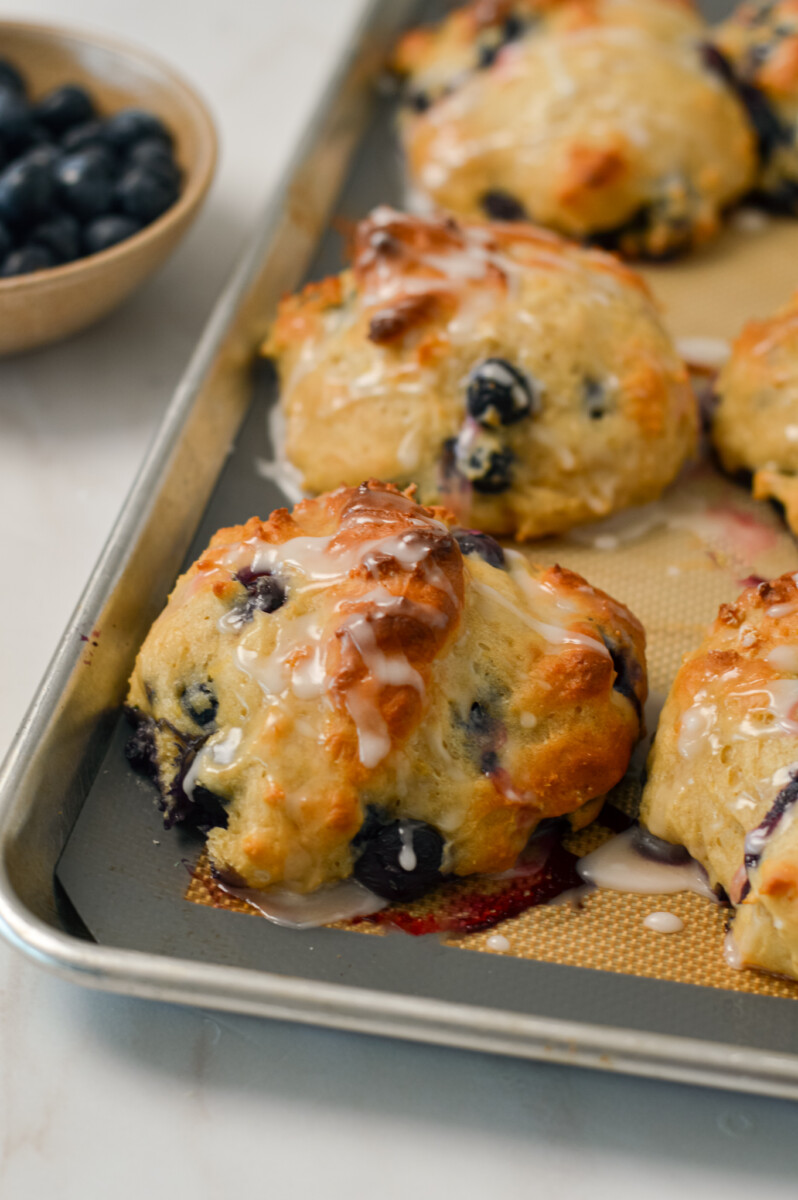 Blueberry biscuits cooked on a baking sheet.