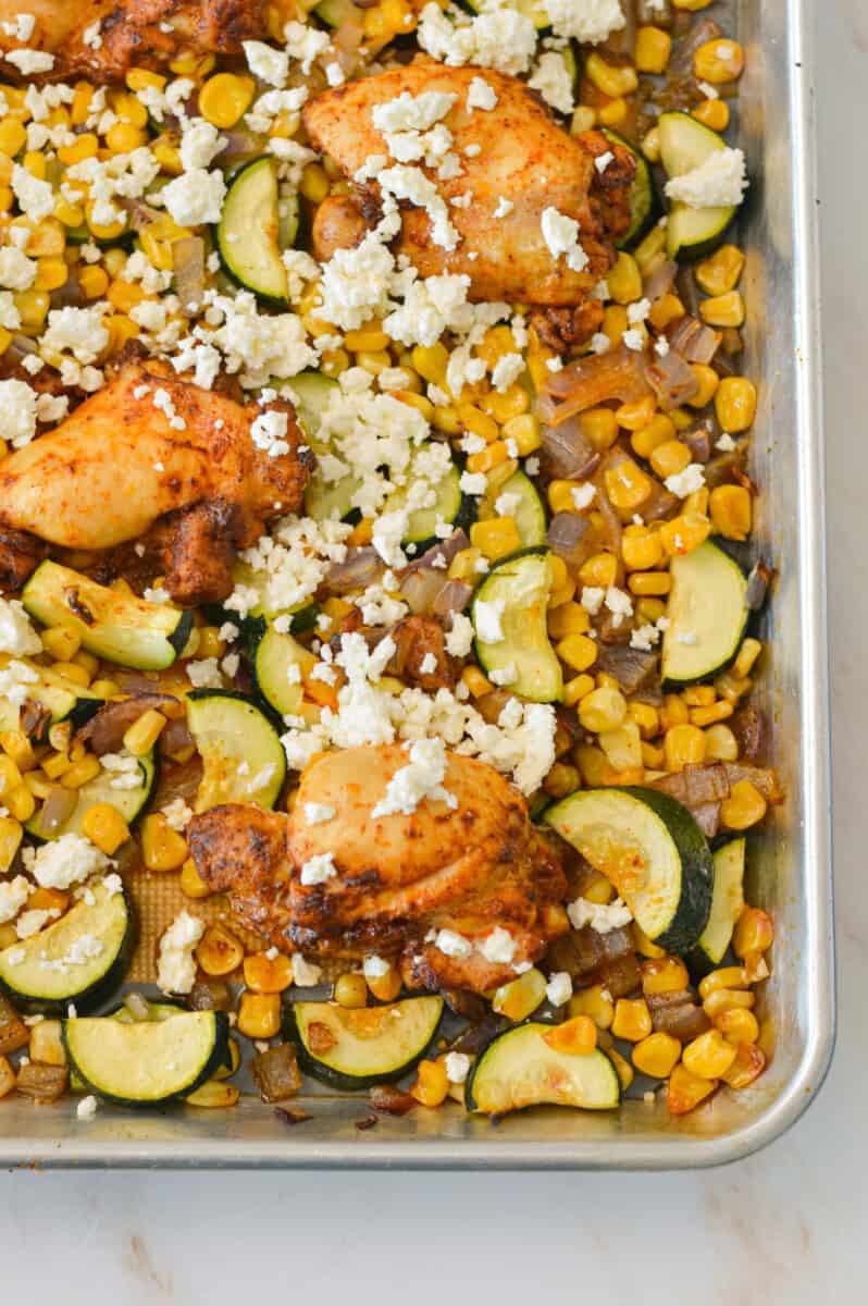 Street corn chicken sheet pan after baking, topped with cotija cheese.