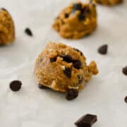 Protein cookie dough ball on a piece of parchment paper.