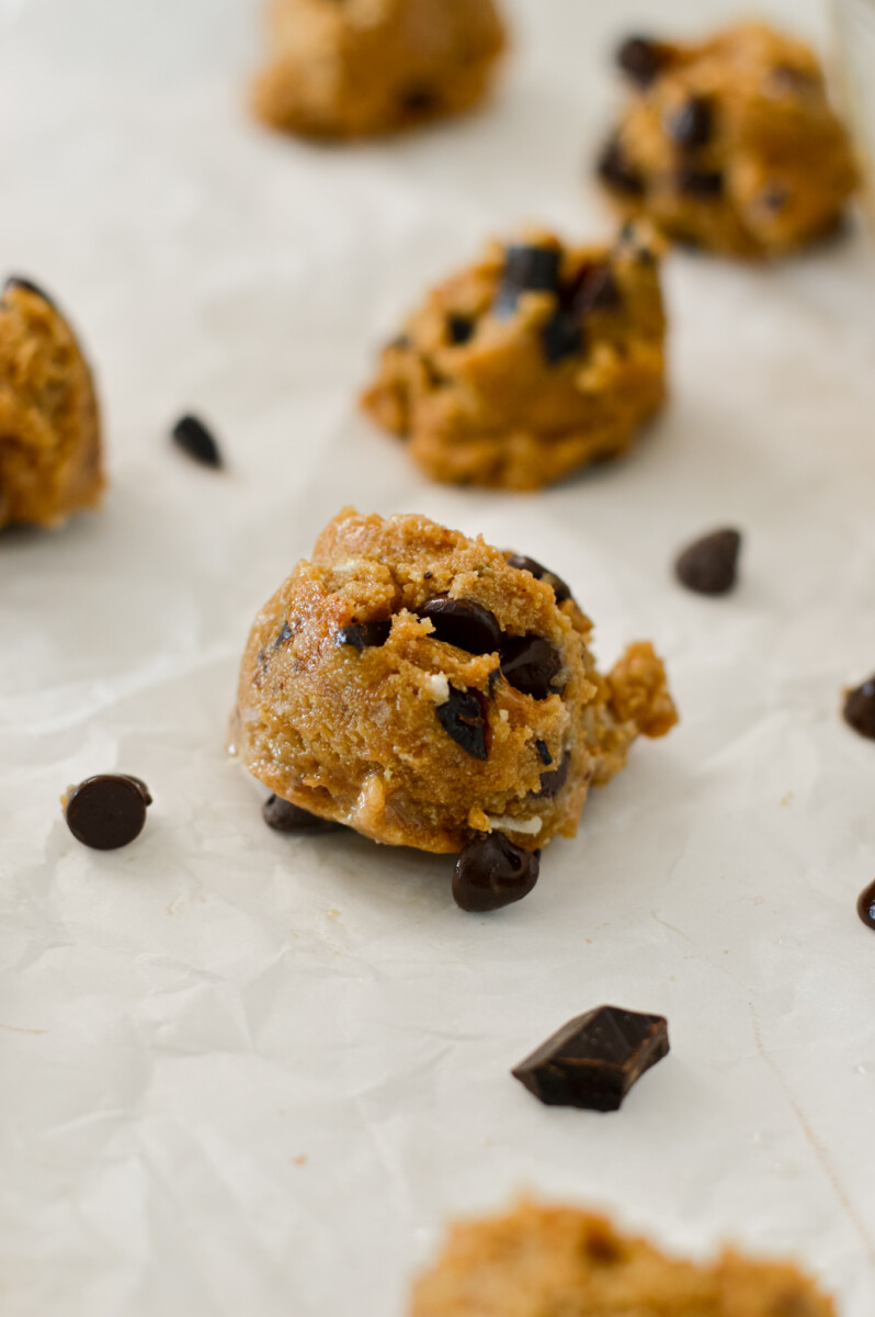 Protein cookie dough ball on a piece of parchment paper.