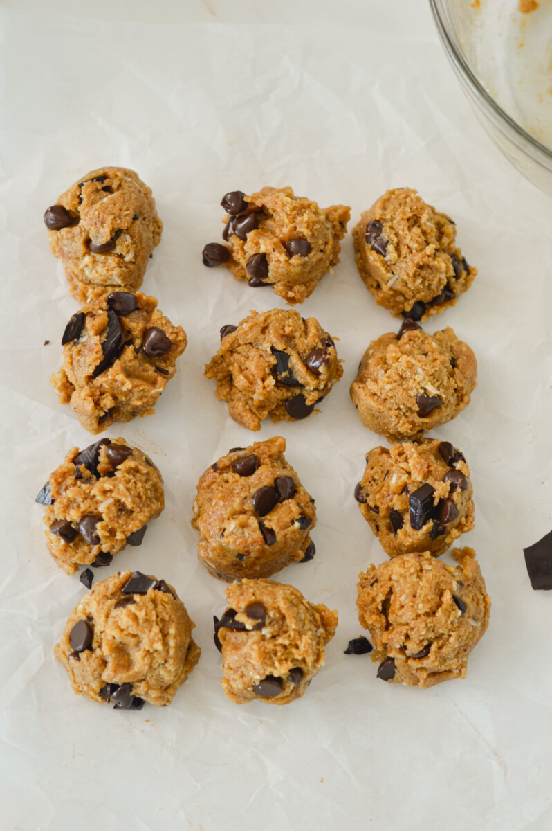 Cookie dough scooped onto a piece of parchment paper.