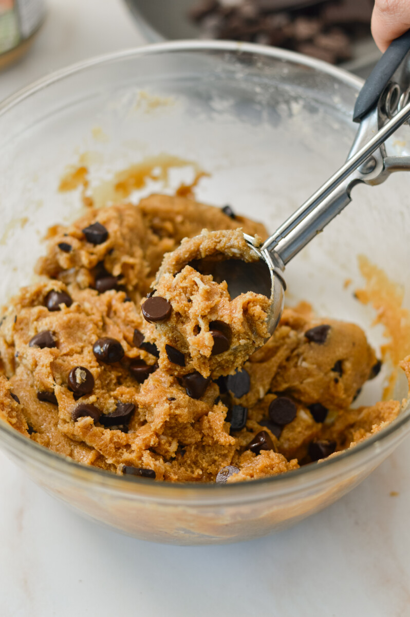 Cookie scoop lifting up cookie dough.
