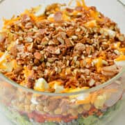 Close up of layered salad in a glass bowl.