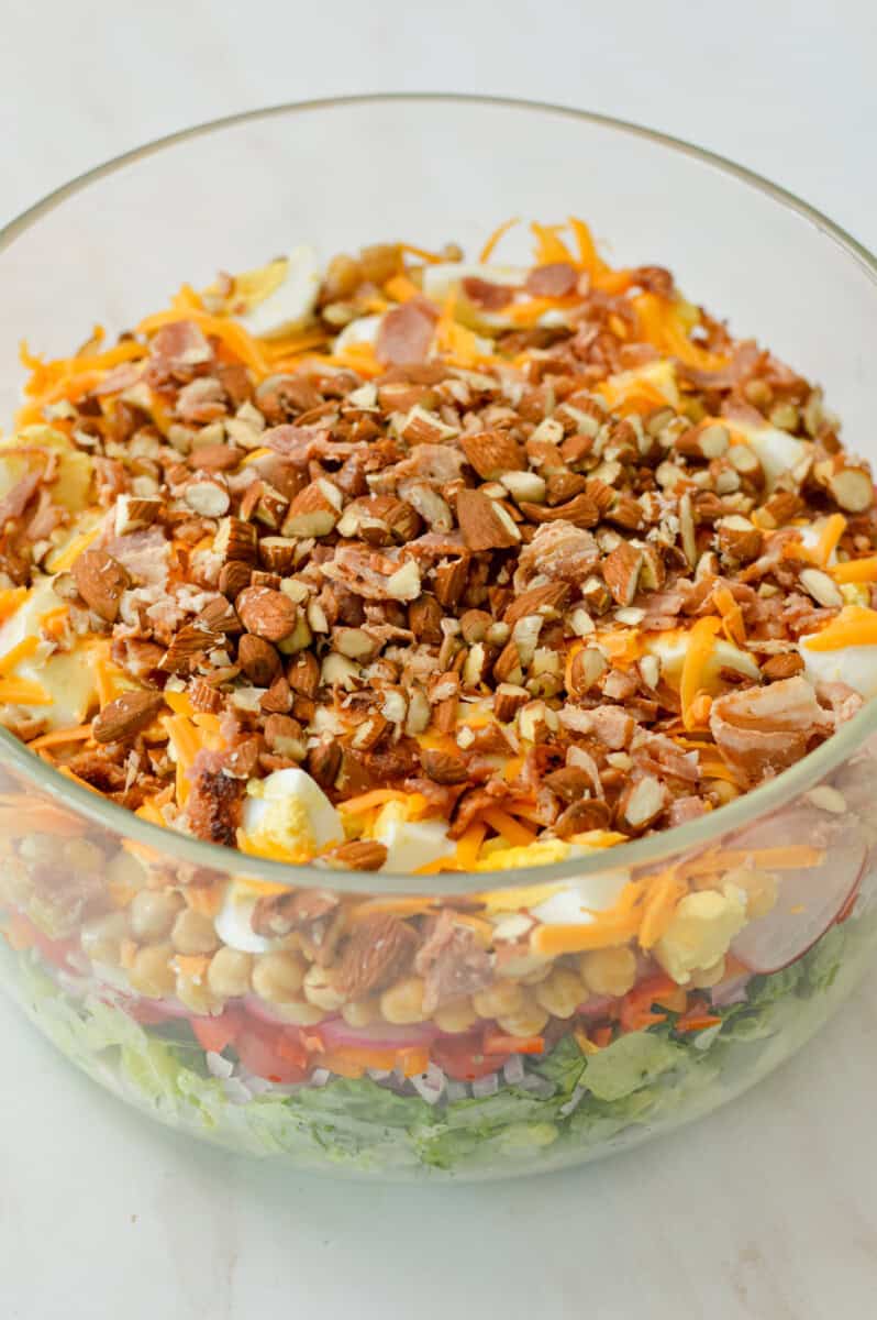 Close up of layered salad in a glass bowl.