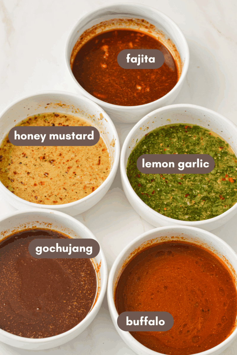 Ingredients for freezer chicken marinades including honey mustard, gochujang, lemon garlic, fajita, and buffalo.