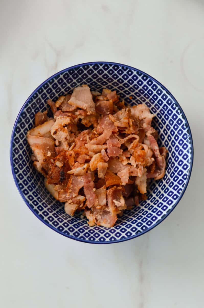 Cooked bacon chopped in a small bowl.