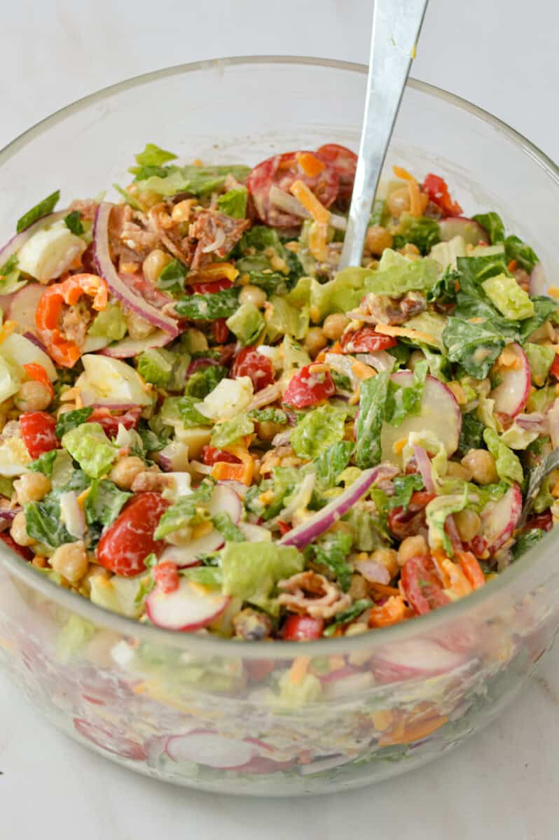 Layered salad tossed in a glass bowl.