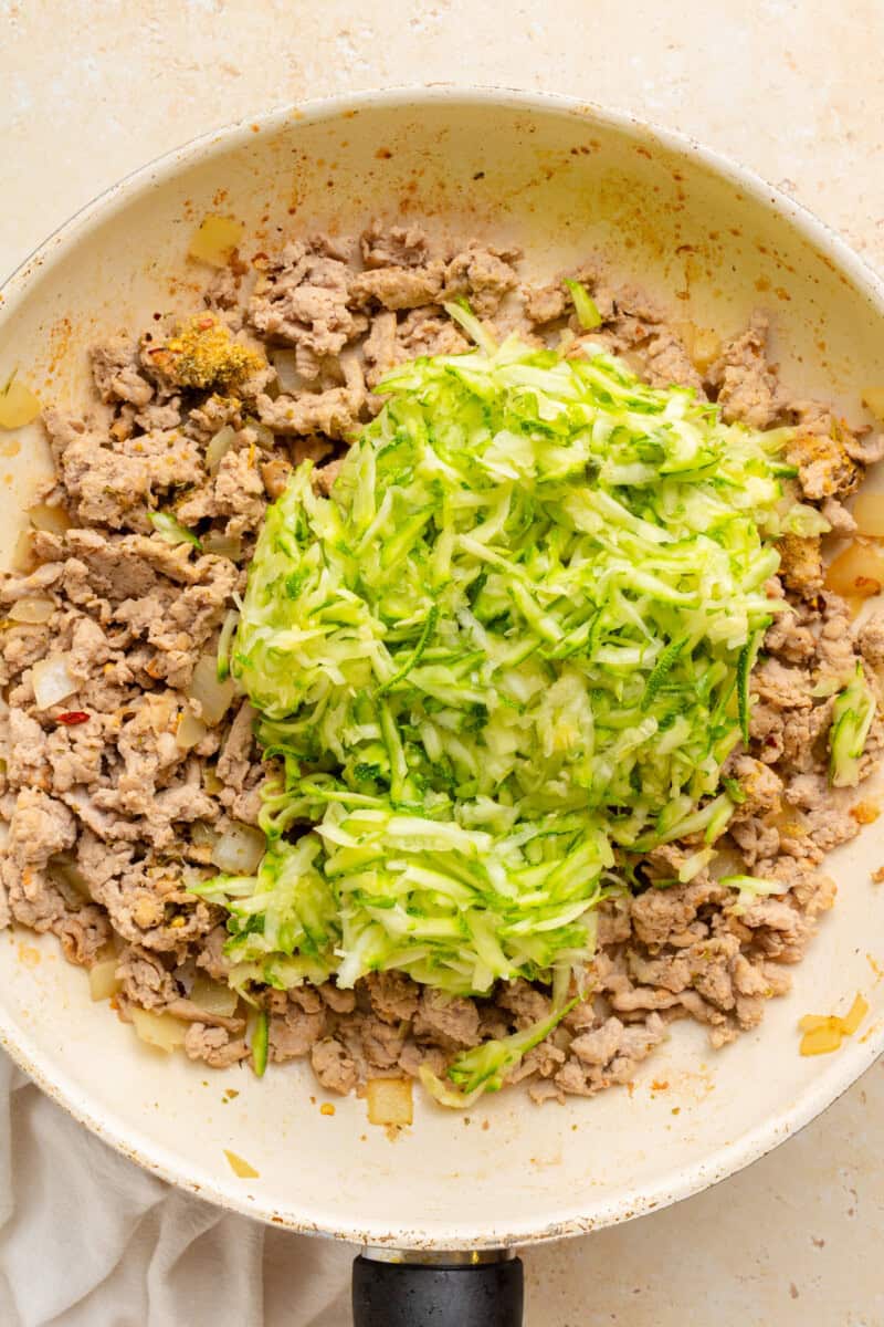 Ground turkey and zucchini in a pan.