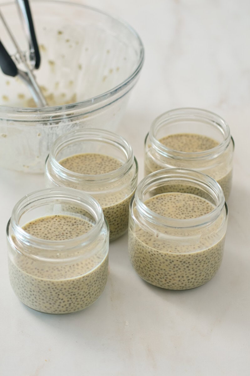 Chia pudding added to four small jars.