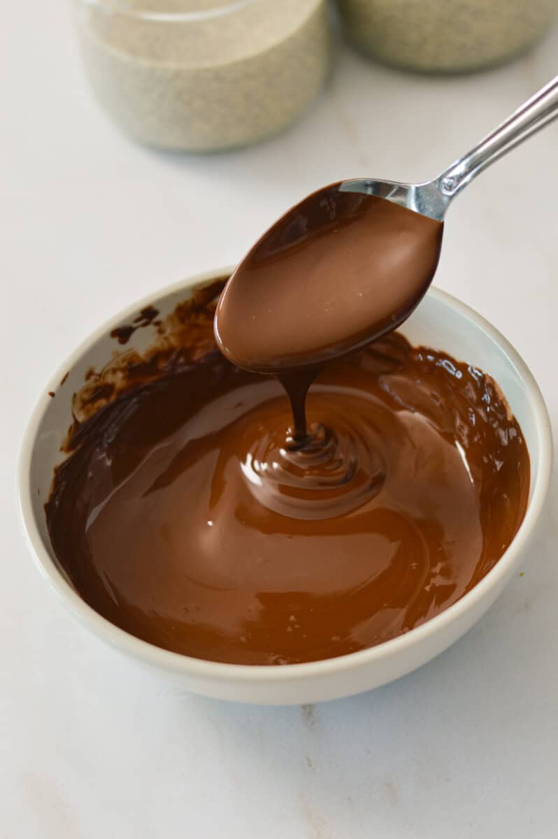 Spoon lifting up melted chocolate.