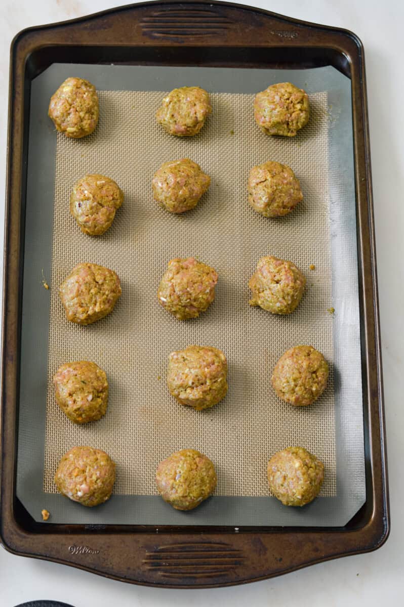 Pesto chicken meatballs on a baking dish.