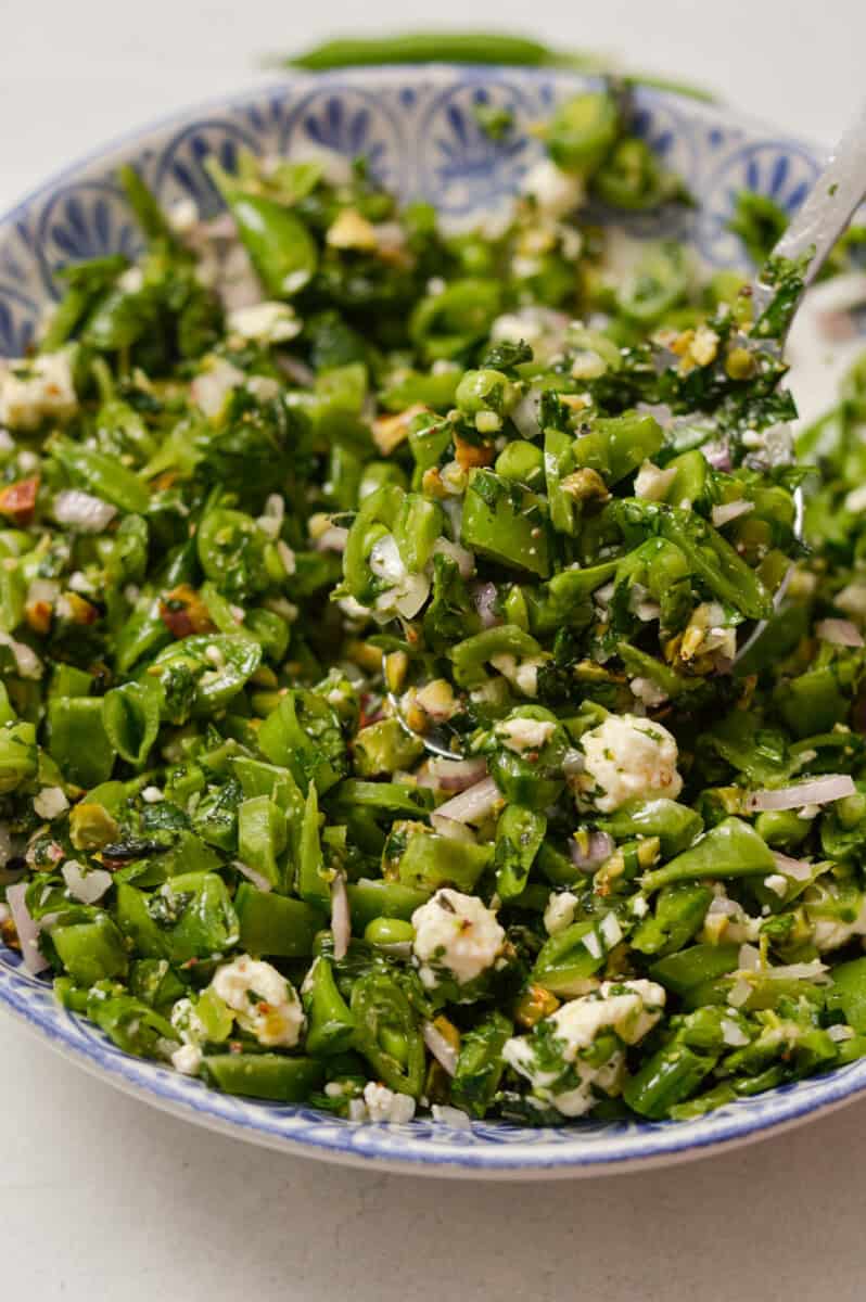 Close up of snap pea salad in a bowl.