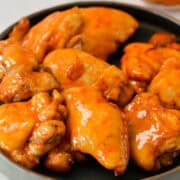 Hot honey chicken thighs on a plate.