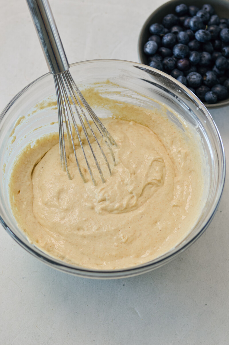 Pancake batter being whisked in a mixing bowl.