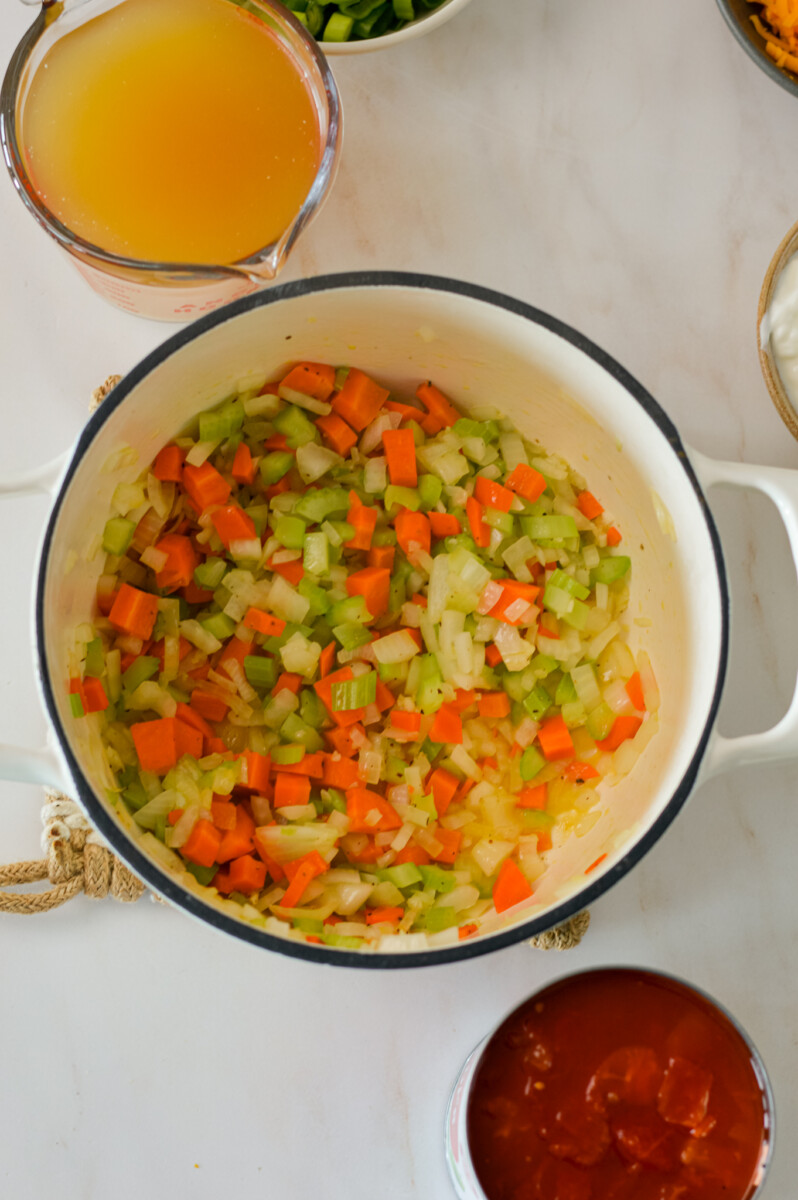Onion, celery and garlic added to a pot.
