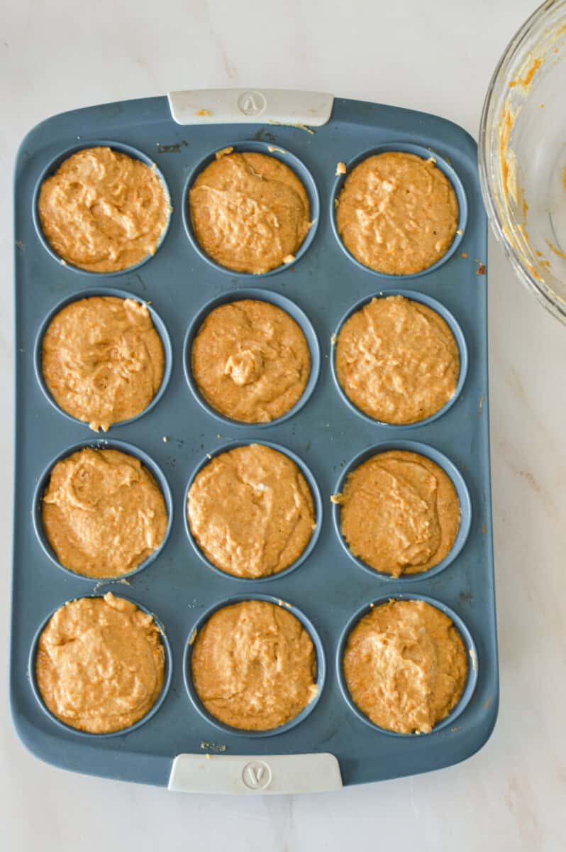 Additional muffin batter added to the muffin tray.