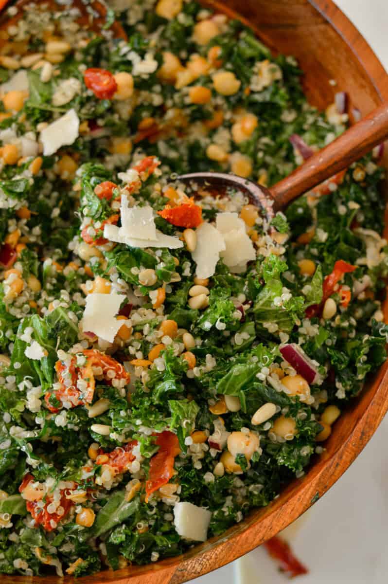 Close up of a salad tong lifting up the Tuscan Kale Quinoa Salad.