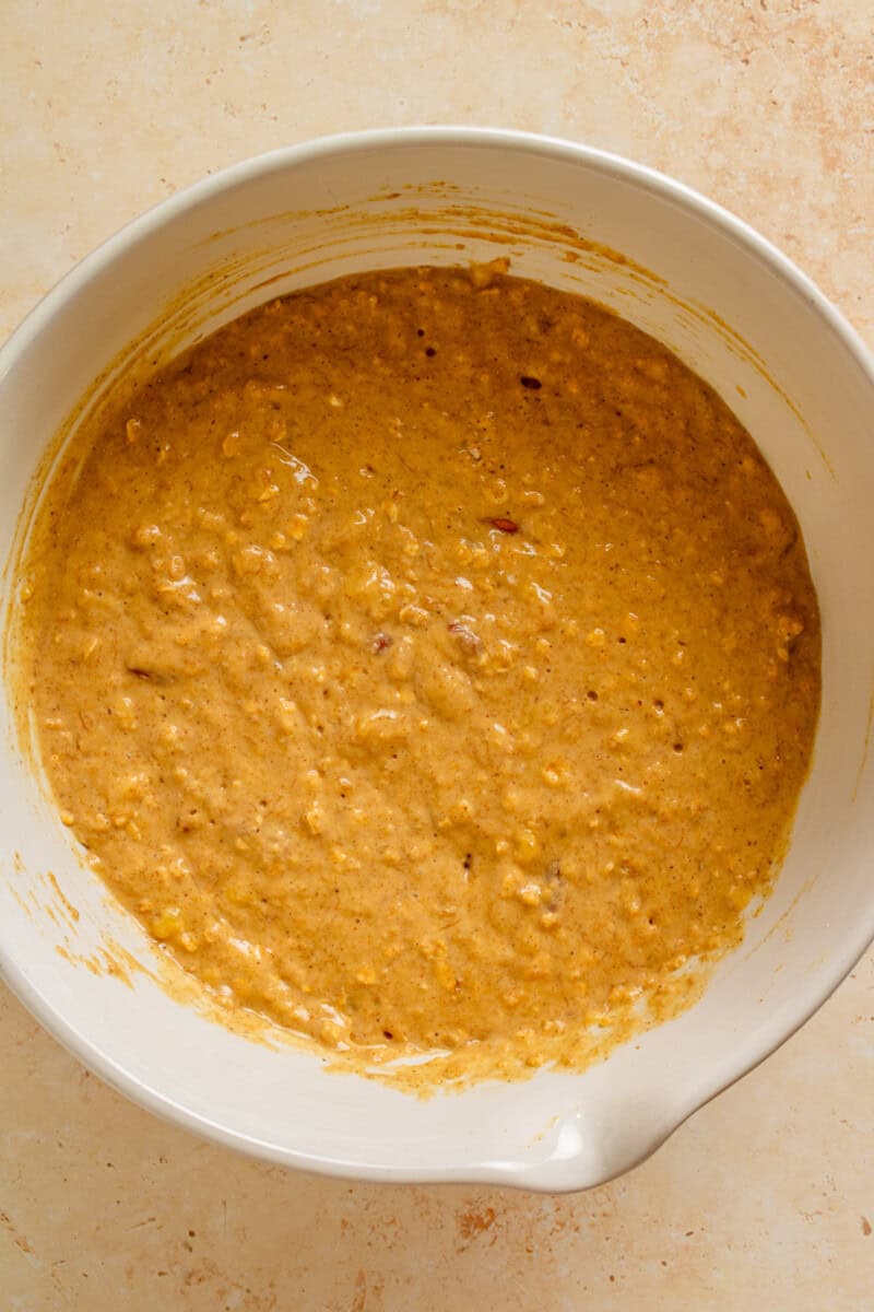 Wet and dry ingredients combined in a mixing bowl.