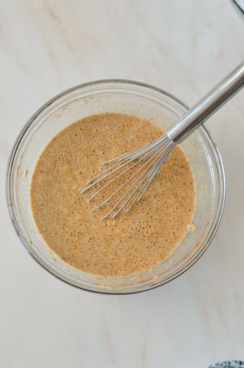 Wet and dry ingredients combined in a mixing bowl.