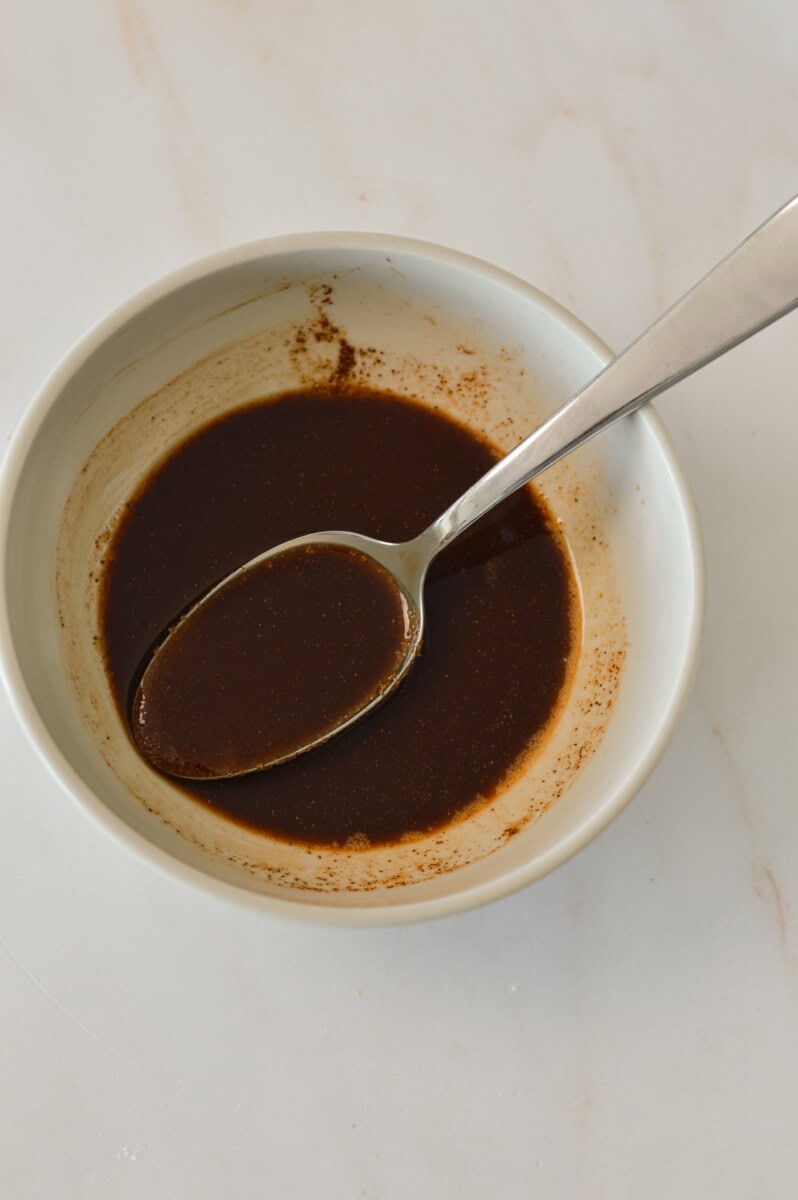 Ingredients for the cinnamon swirl combined in a small bowl with a spoon.